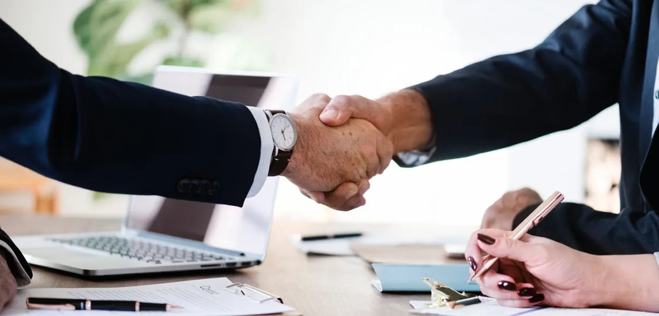 Stretta di mano tra due professionisti alla scrivania
